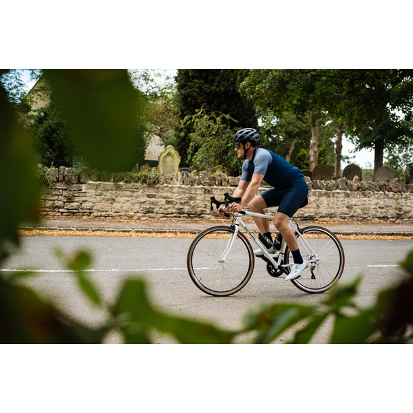 Equilibrium Large White Steel Road Bike – Lightweight Reynolds 725 Frame, Timeless Comfort 17 Equilibrium white steel road bike parked in city setting